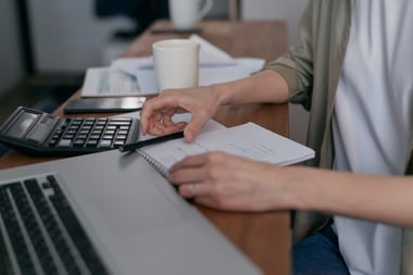 Person at a desk with notepad and calculator