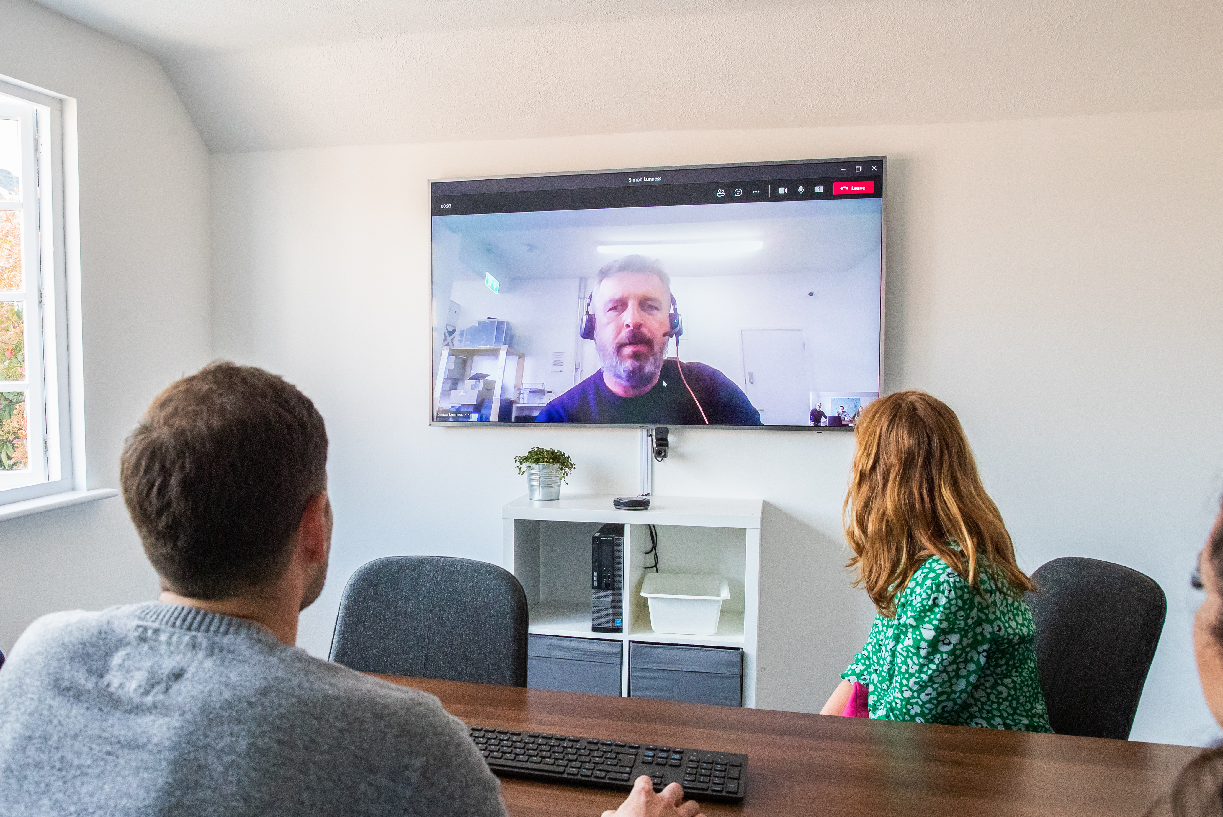 Video meeting with man on a big screen
