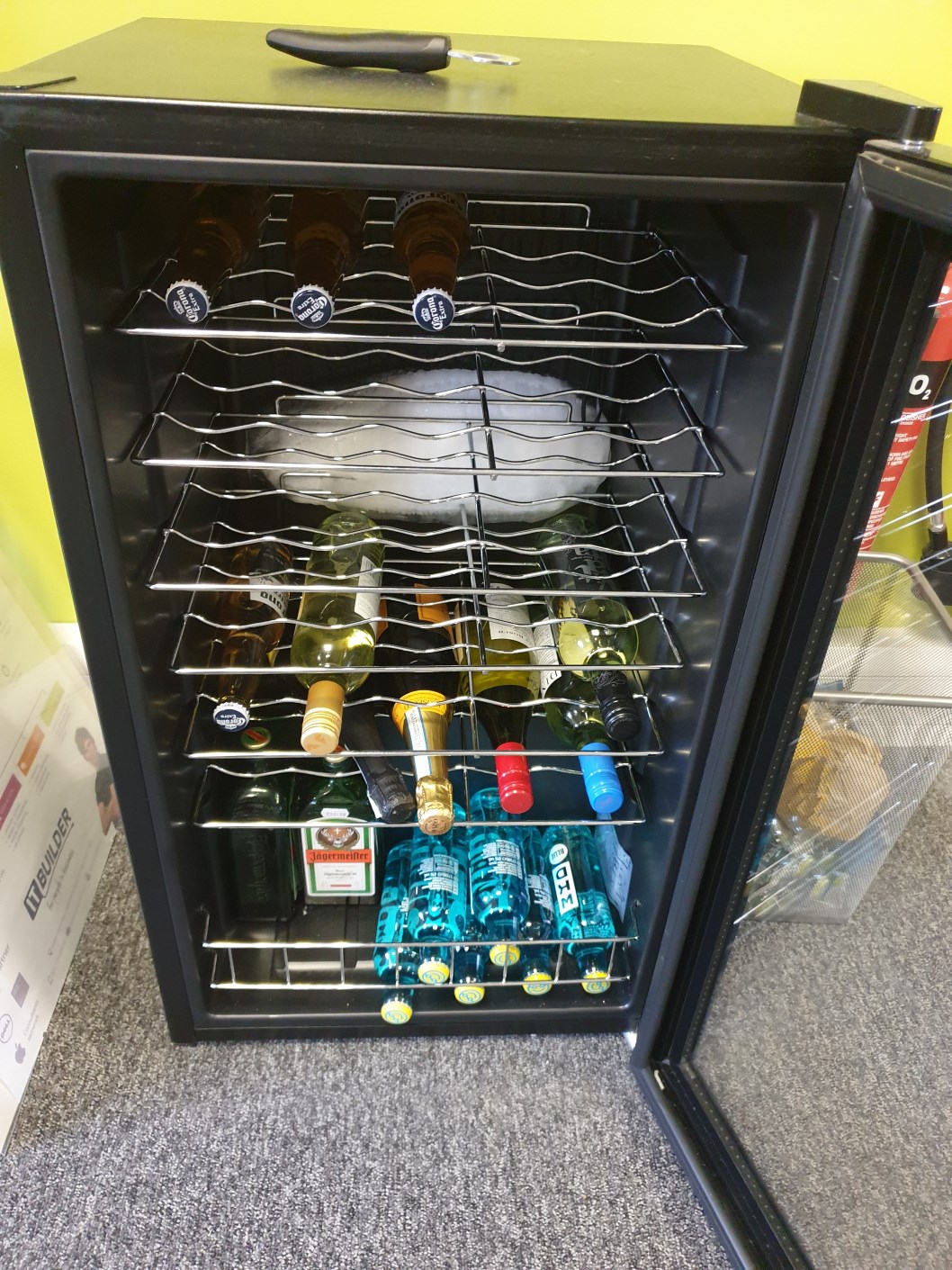 A fridge with bottles of beer and wine