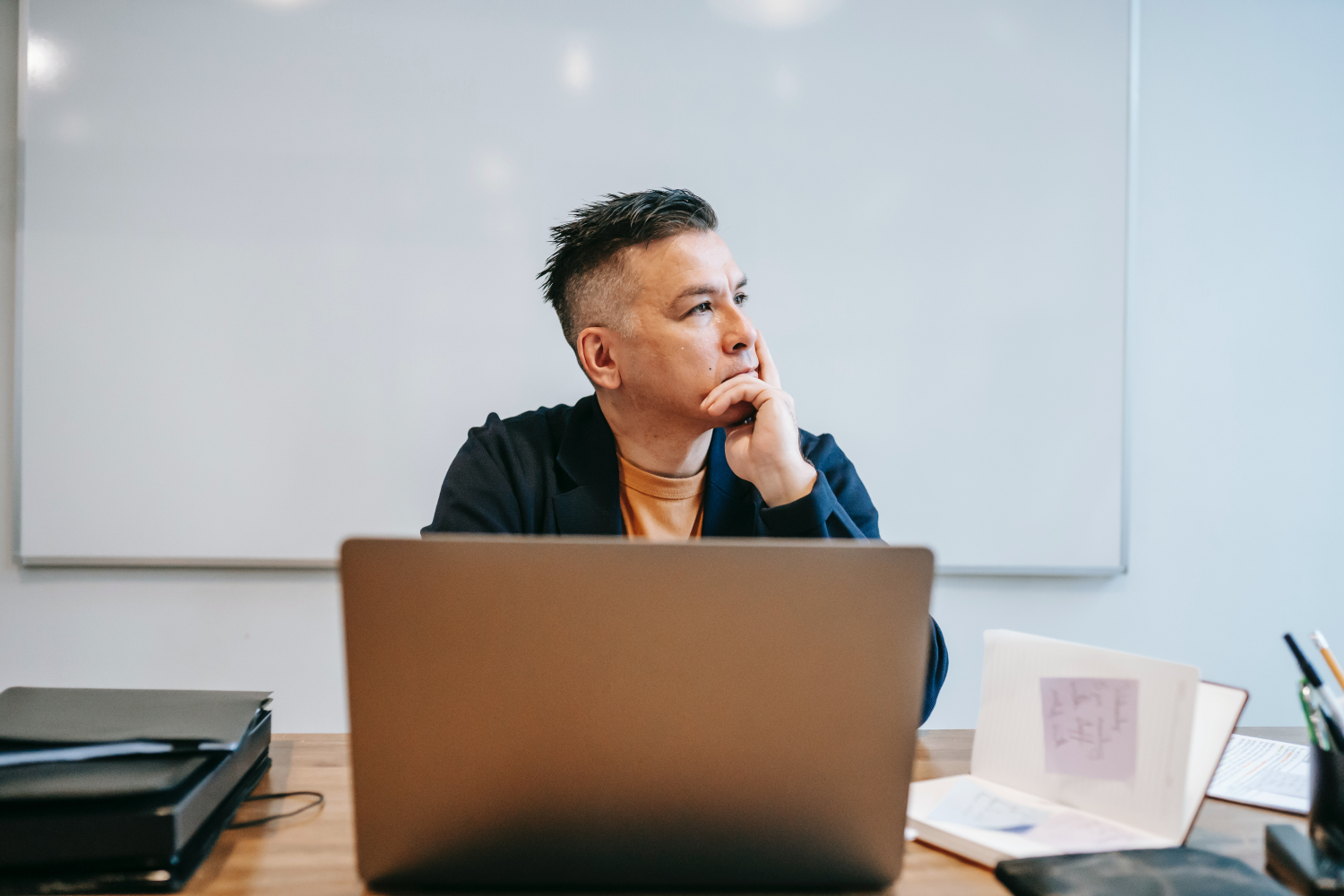 A man sat thoughtfully at a computer